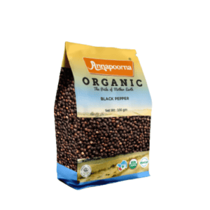 Annapoorna Organic Black Pepper packaging, predominantly yellow with a photographic image of black pepper, indicating it as a 100 grams organic product with the tagline 'The Pride of Mother Earth' and various certification logos.