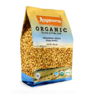 Annapoorna Organic Fenugreek Seeds packaging, predominantly yellow with a visual of fenugreek seeds. The package indicates it as a 100 grams organic product with the tagline 'The Pride of Mother Earth' and USDA Organic and India Organic certification logos.