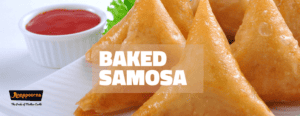 Three freshly baked samosas on a white plate, accompanied by a bowl of red sauce, with the title 'Baked Samosa', indicating a healthier alternative to the traditional deep-fried samosa.